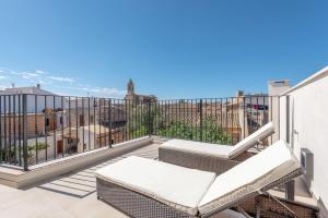 a balcony with chairs and a view of the city at Es Campanar in Santanyi