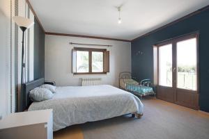 a bedroom with a large bed with blue walls at Melquites Country House in Barrantes +37 photos