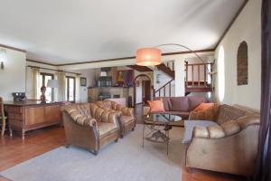 a living room with leather couches and a table at Melquites Country House in Barrantes