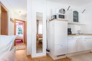 a kitchen with a white cabinet and a microwave at Voglsang - Haus Annamirl in Bayrischzell +18 photos