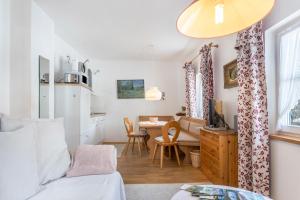 a room with a bed and a desk and a kitchen at Voglsang - Haus Annamirl in Bayrischzell