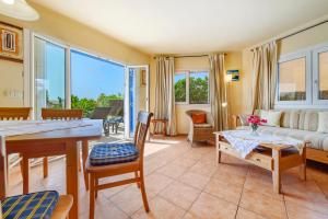 a living room with a couch and a table and chairs at Casa Folara in Cala Llombards