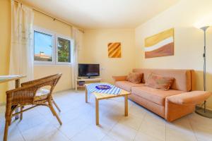 a living room with a couch and a table at Casa Folara in Cala Llombards
