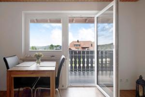 a dining room with a table and a large window at Haus Fritz in Wittenschwand