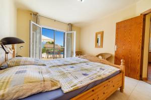 a bedroom with a bed with a view of a patio at Casa Folara in Cala Llombards +22 photos