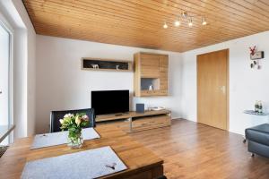 a living room with a table and a tv at Haus Fritz in Wittenschwand