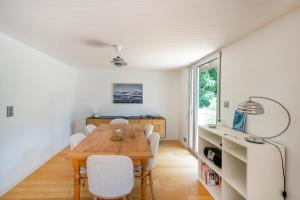 a dining room with a wooden table and white chairs at Villa Piscine Entre Lac et Océan in Soorts-Hossegor