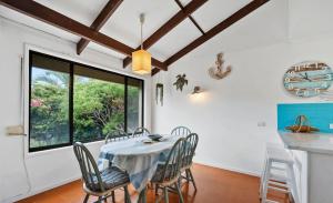 a dining room with a table and chairs and a window at Casa Bella in Bongaree