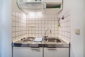 a small kitchen with a sink and a stove at Nordhaus Ferienwohnung 6 in Cuxhaven +20 photos