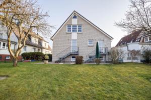 a large house with a grass yard in front of it at Nordhaus Ferienwohnung 6 in Cuxhaven