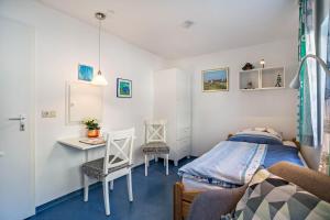 a bedroom with a bed and a table and chairs at Nordhaus Ferienwohnung 6 in Cuxhaven