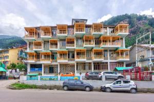a large building with cars parked in front of it at MHA hotel ever green manali in Manāli