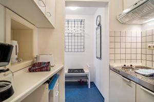 a kitchen with white walls and blue flooring at Nordhaus Ferienwohnung 6 in Cuxhaven