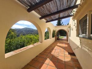 an external view of a house with an arched walkway at Casa tranquila torrox in Cómpeta