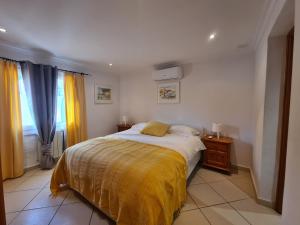 a bedroom with a bed with a yellow blanket at Casa tranquila torrox in Cómpeta +16 photos