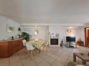 a kitchen and living room with a table and a television at Casa tranquila torrox in Cómpeta