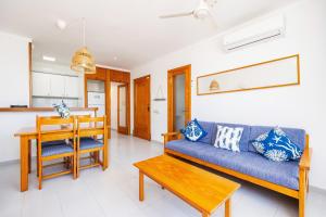 a living room with a blue couch and a table at Can Vidal Cabrera in Ses Salines