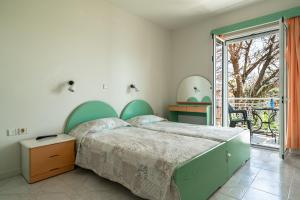 a bedroom with a large bed and a balcony at Angela partial sea view 5 in Kefallonia