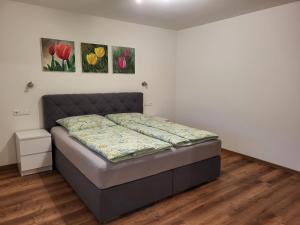 a bed in a room with two paintings on the wall at Ferienwohnung Felsenblick in Albstadt