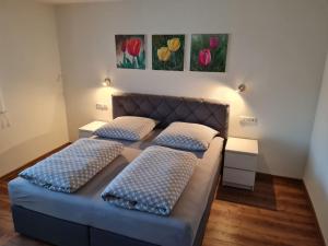 two beds in a room with flowers on the wall at Ferienwohnung Felsenblick in Albstadt +37 photos