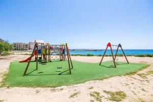 a playground on the beach with the ocean in the background at Can Vidal Cabrera in Ses Salines