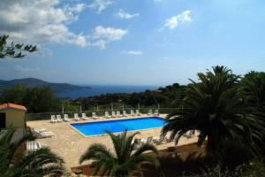 a swimming pool with chairs and a view of the ocean at Mono Le Lecce 38b in Capoliveri