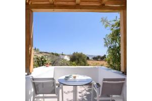 a patio with a table and chairs and a view at Echinousa Kimolos katoikia no6 in Kimolos