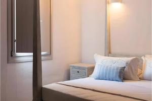 a bed with a mirror and a blue pillow on it at Echinousa Kimolos katoikia no6 in Kimolos