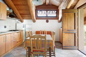 a kitchen with a table and chairs and wooden ceilings at Anemone Tano di Grich in Cesani +14 photos