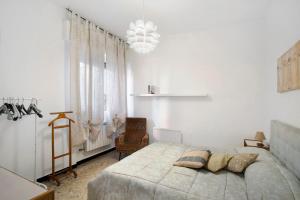 a white bedroom with a large bed and a chair at Alassio Mare E Non Solo 2 in Alassio