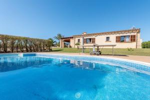 a large blue swimming pool in front of a house at Can Siurell in Artá