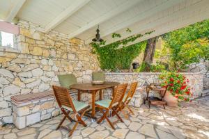a patio with a table and chairs on a stone wall at Villa Faye in Gaios