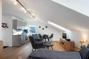 a living room with a couch and chairs and a kitchen at Waldglück Apartment in Feldberg +11 photos