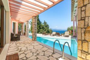 a patio with a swimming pool and a house at Villa Faye in Gaios