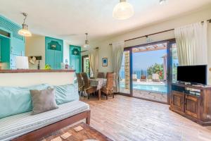 a living room with a couch and a television at Villa Faye in Gaios