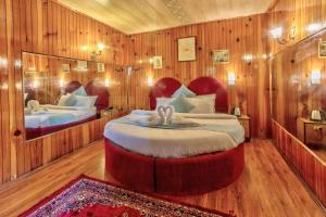 a bedroom with a large bed in a room with wooden walls at MHA hotel ever green manali in Manāli +14 photos