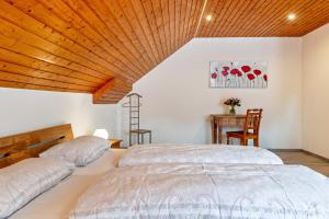two beds in a bedroom with a wooden ceiling at Jeglehof in Salem
