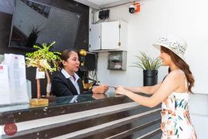 a woman in a dress is talking to a man at Sioland Grand Premier Hotel Candelaria in Candelaria
