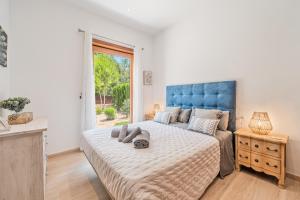 a bedroom with a large bed with a blue headboard at Villa Sa Olivera in Crestatx +25 photos