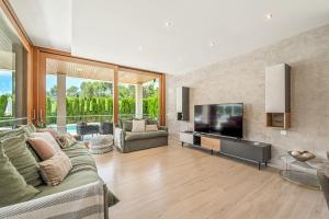 a living room with a couch and a flat screen tv at Villa Sa Olivera in Crestatx