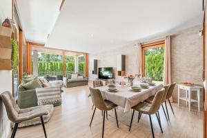 a dining room with a table and chairs and a living room at Villa Sa Olivera in Crestatx