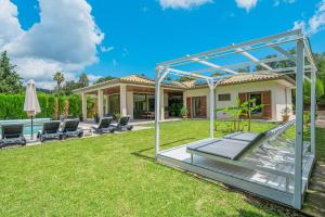 a backyard with chairs and a house at Villa Sa Olivera in Crestatx