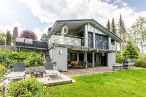 a house with a balcony and a yard at Ferienwohnung Eulennest in Schramberg