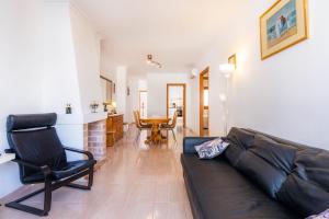 a living room with a couch and a chair and a table at Can Miquel in Can Picafort