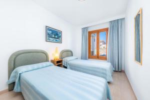 a room with two beds and a window at Can Miquel in Can Picafort +22 photos