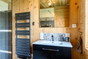 a bathroom with a sink and a mirror at Chalet le Brusyna avec jacuzzi in Saint-Maurice-sur-Moselle +24 photos
