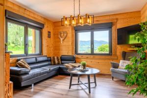 a living room with a couch and a table at Chalet le Brusyna avec jacuzzi in Saint-Maurice-sur-Moselle