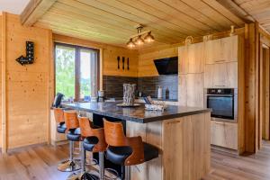 a kitchen with a large island with bar stools at Chalet le Brusyna avec jacuzzi in Saint-Maurice-sur-Moselle
