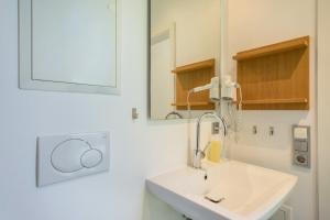 a white bathroom with a sink and a mirror at Ferienhaus Am Heidenbach in Deggenhausertal +22 photos
