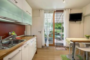 a kitchen with white cabinets and a table and a window at Ferienhaus Am Heidenbach in Deggenhausertal